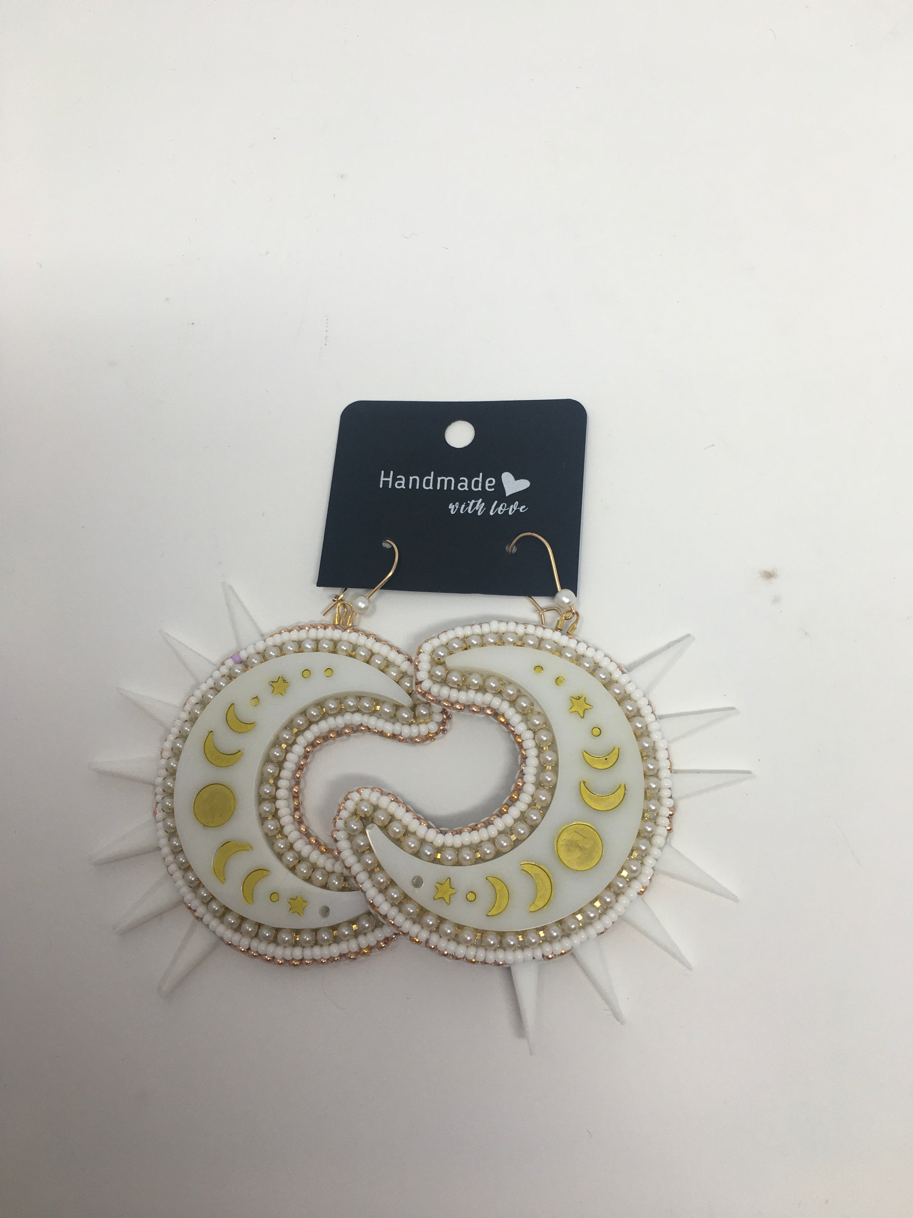 Sunny Poloz white and gold moon dangle earrings with spikes